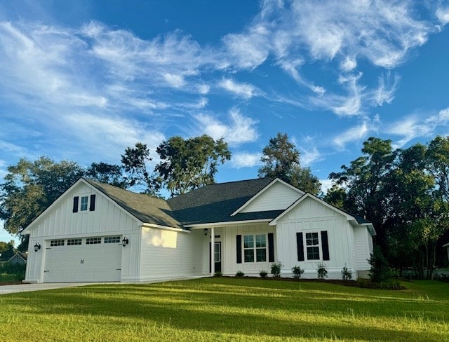 view of front facade with a garage, concrete driveway, board and batten siding, and a front yard