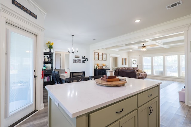 kitchen with light wood finished floors, coffered ceiling, visible vents, a kitchen island, and open floor plan
