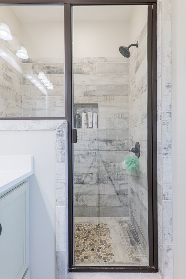 bathroom with a shower stall and vanity