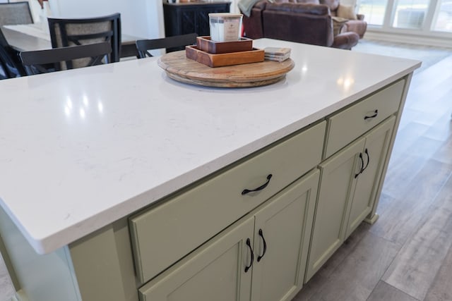 kitchen featuring wood finished floors and light stone counters
