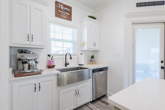 kitchen featuring stainless steel dishwasher, wood finished floors, a sink, backsplash, and white cabinetry