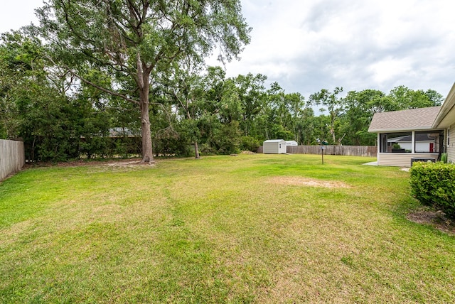 view of yard with fence, an outdoor structure, and a shed
