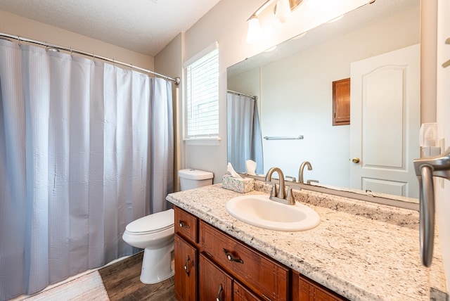 bathroom featuring vanity, wood finished floors, and toilet