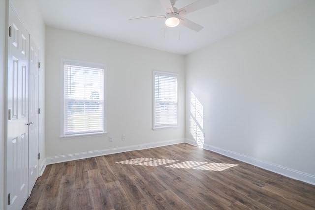 spare room with a wealth of natural light, dark hardwood / wood-style flooring, and ceiling fan