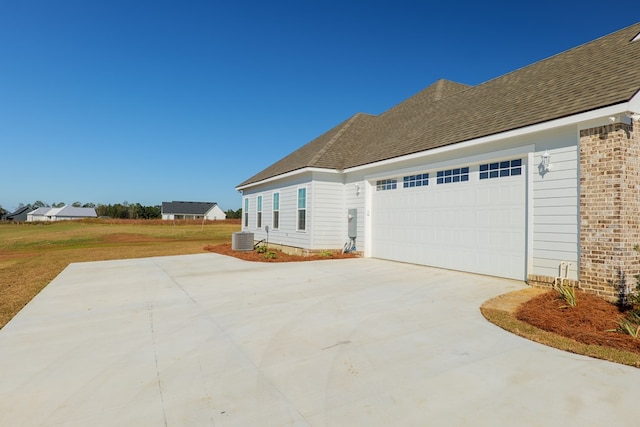 view of front of home featuring cooling unit and a garage