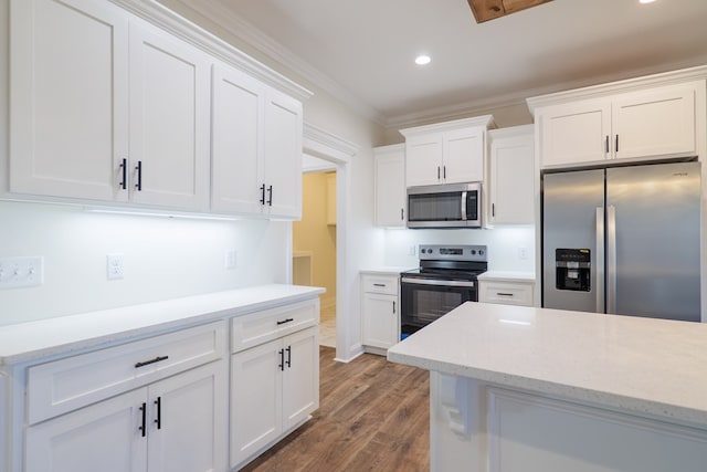 kitchen with white cabinetry, dark wood-type flooring, light stone counters, appliances with stainless steel finishes, and ornamental molding