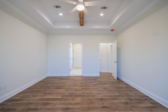 unfurnished bedroom featuring a tray ceiling, crown molding, ceiling fan, and dark wood-type flooring