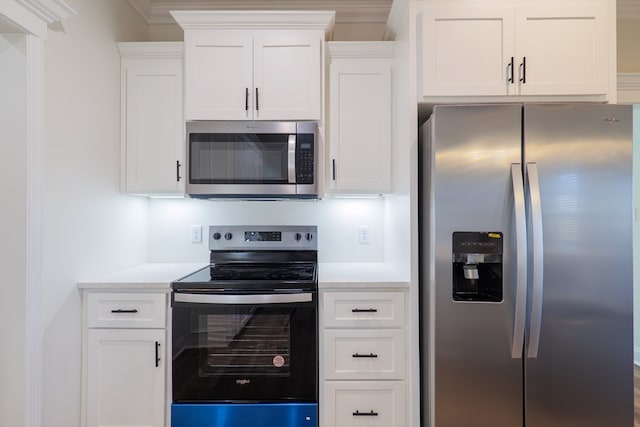 kitchen featuring crown molding, white cabinets, and stainless steel appliances