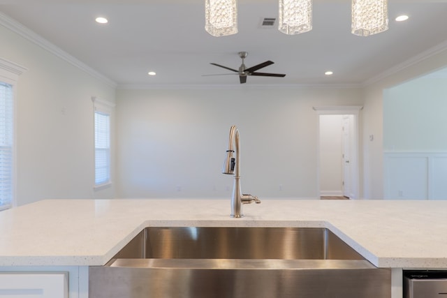 kitchen featuring pendant lighting, ceiling fan, crown molding, and sink