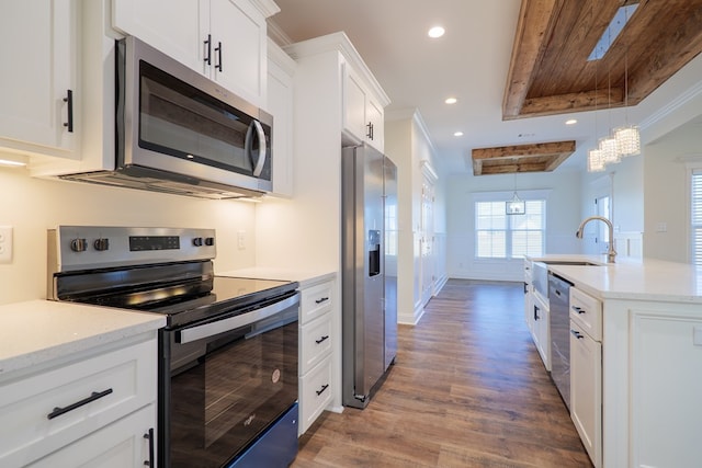 kitchen with sink, decorative light fixtures, white cabinetry, wood-type flooring, and stainless steel appliances