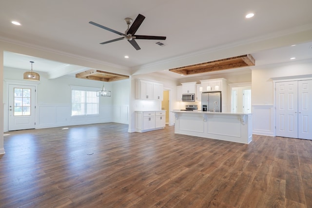 unfurnished living room with crown molding, dark hardwood / wood-style flooring, beamed ceiling, and ceiling fan with notable chandelier