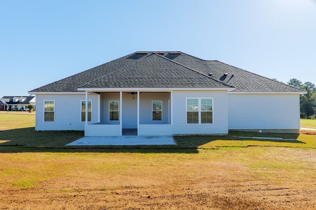 rear view of house with a patio, ceiling fan, and a lawn