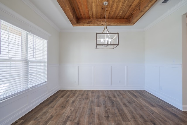 unfurnished dining area with a notable chandelier, dark hardwood / wood-style flooring, a raised ceiling, and ornamental molding