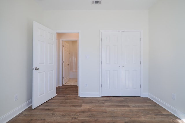 unfurnished bedroom with a closet and dark wood-type flooring