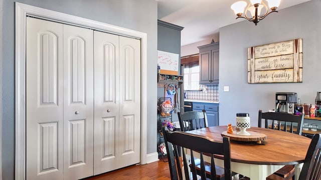 dining room with baseboards, an inviting chandelier, and dark wood-style flooring