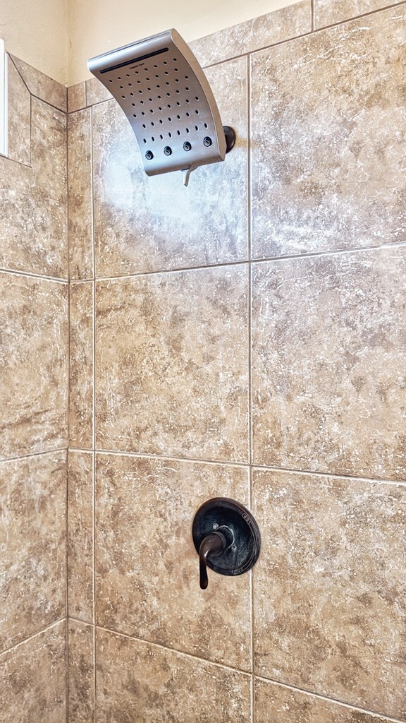 interior details featuring a tile shower