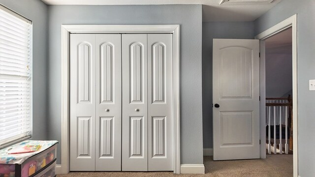 bedroom with carpet flooring, baseboards, and a closet