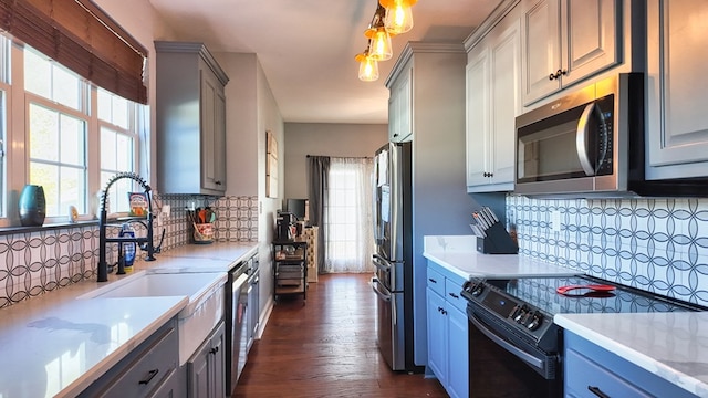 kitchen with dark wood-type flooring, tasteful backsplash, gray cabinets, and appliances with stainless steel finishes