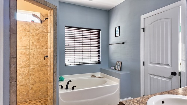 bathroom featuring a sink, tiled shower, and a bath