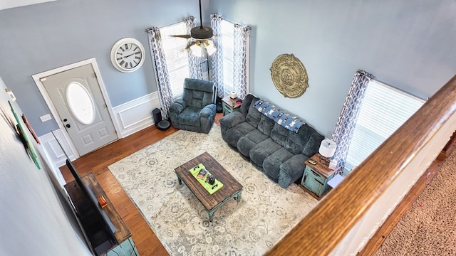 living area with a decorative wall, wainscoting, and wood finished floors