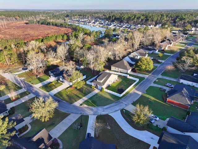 bird's eye view featuring a residential view, a water view, and a wooded view