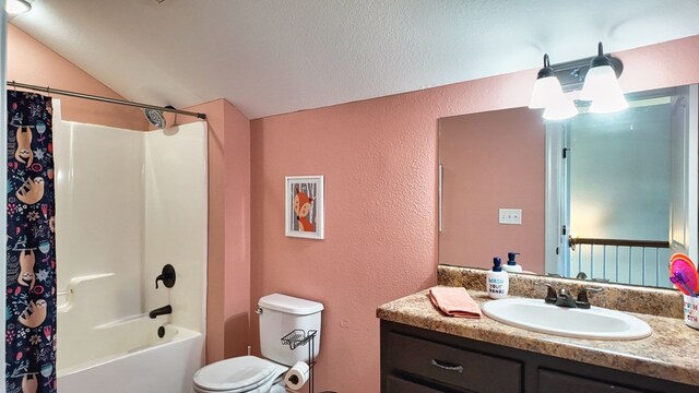 full bath with toilet, vanity, shower / bath combo with shower curtain, a textured wall, and a textured ceiling