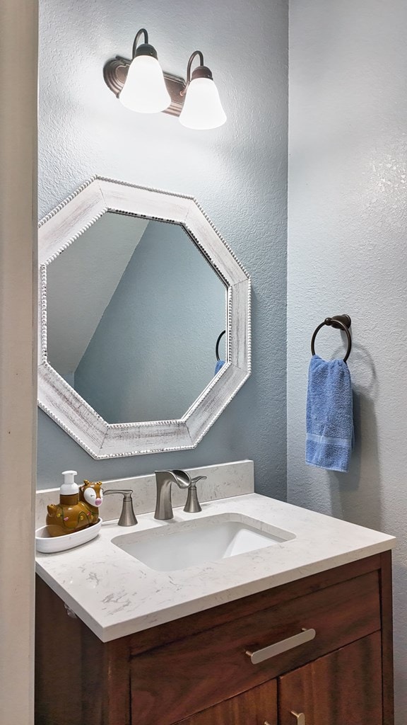 bathroom with vanity and a textured wall