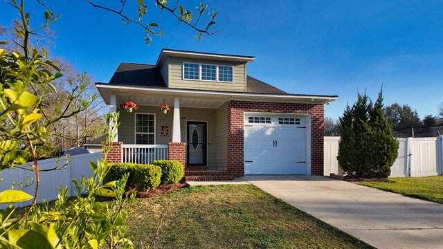 view of front facade with driveway, a porch, fence, an attached garage, and brick siding