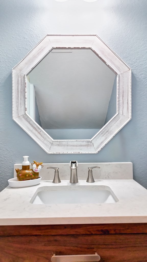 interior details with vanity and a textured wall