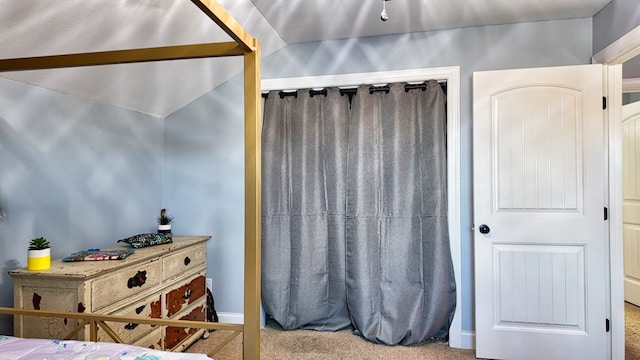 carpeted bedroom with lofted ceiling