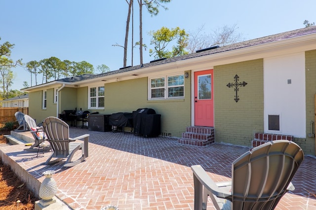 back of house with a patio, brick siding, and entry steps