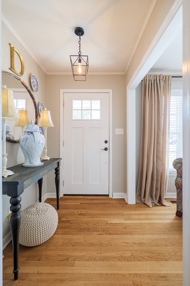 entryway with plenty of natural light, baseboards, light wood-style floors, and ornamental molding