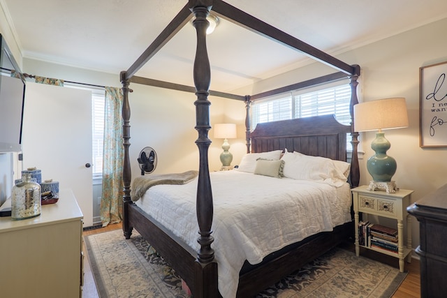 bedroom featuring ornamental molding and wood finished floors