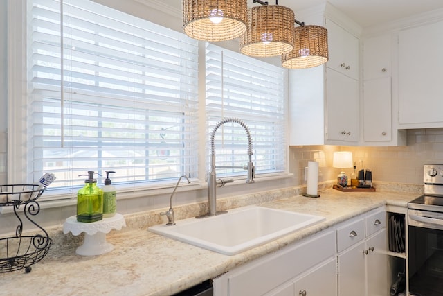 kitchen with backsplash, crown molding, electric range, white cabinetry, and a sink