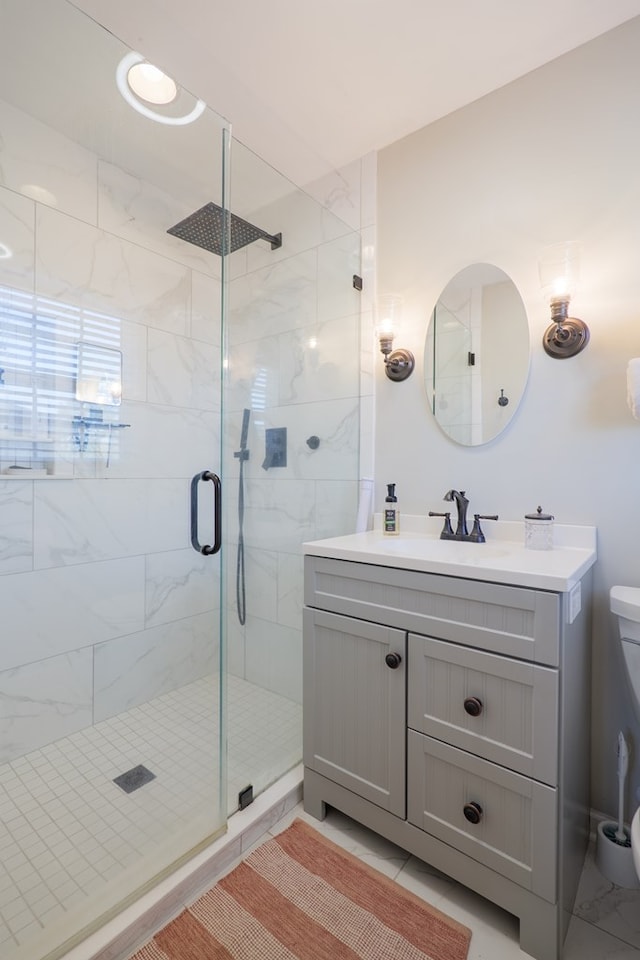 bathroom with toilet, a stall shower, and vanity