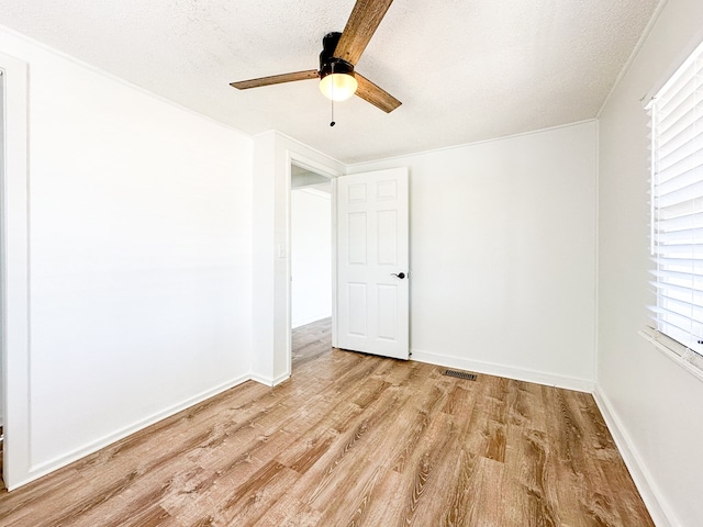 unfurnished room featuring ceiling fan, light hardwood / wood-style floors, and a textured ceiling