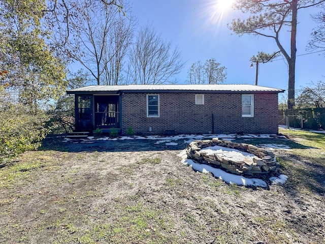 back of property with an outdoor fire pit