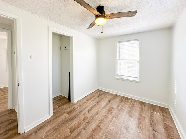 unfurnished bedroom featuring a textured ceiling, ceiling fan, and light hardwood / wood-style floors