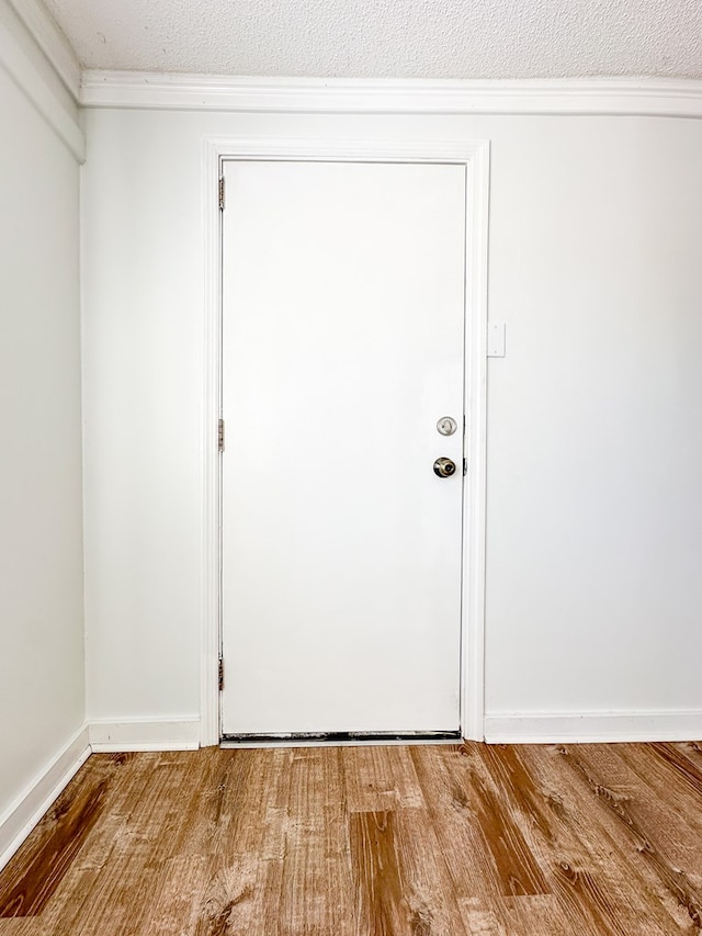 doorway to outside featuring wood-type flooring and a textured ceiling