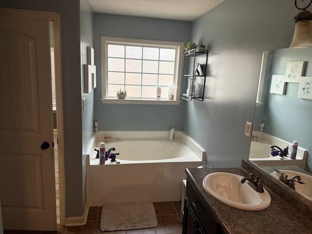 bathroom with tile patterned floors, a tub to relax in, and vanity