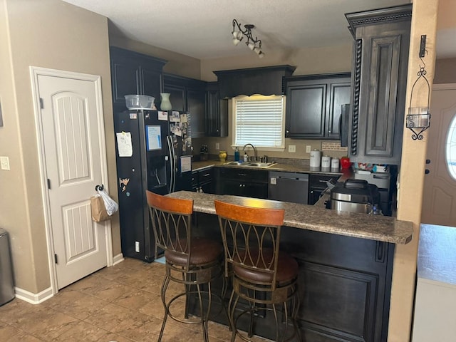 kitchen with a kitchen breakfast bar, kitchen peninsula, sink, and black appliances