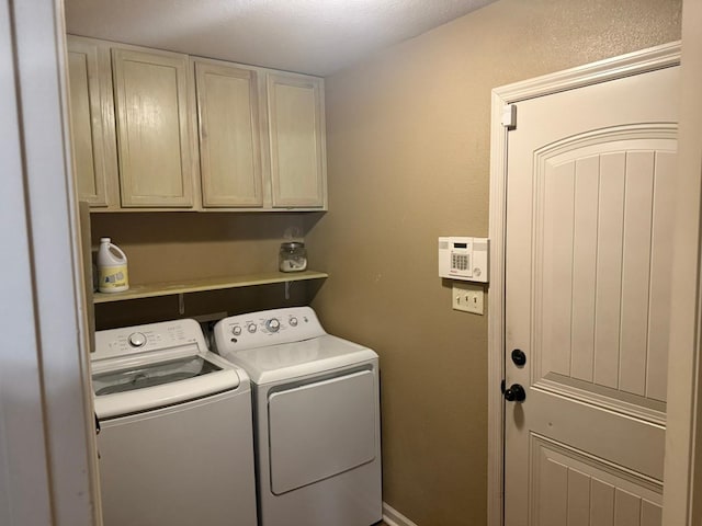 washroom featuring cabinets and separate washer and dryer