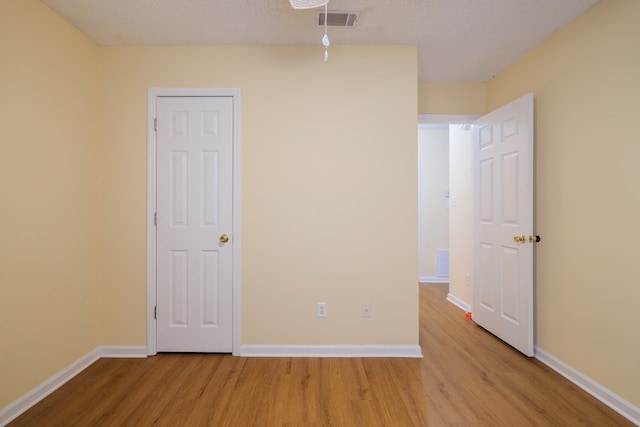 interior space with a textured ceiling and light hardwood / wood-style flooring