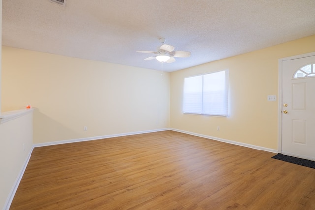 entryway with a textured ceiling, hardwood / wood-style flooring, and ceiling fan