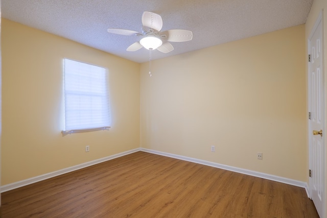 spare room featuring a textured ceiling, light wood-type flooring, and ceiling fan