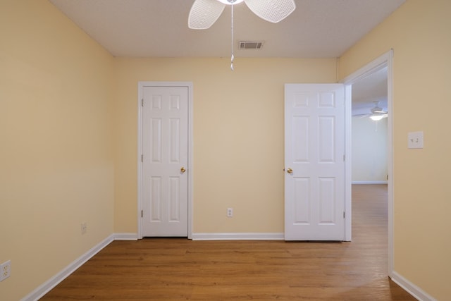 unfurnished bedroom featuring a textured ceiling, light hardwood / wood-style floors, and ceiling fan