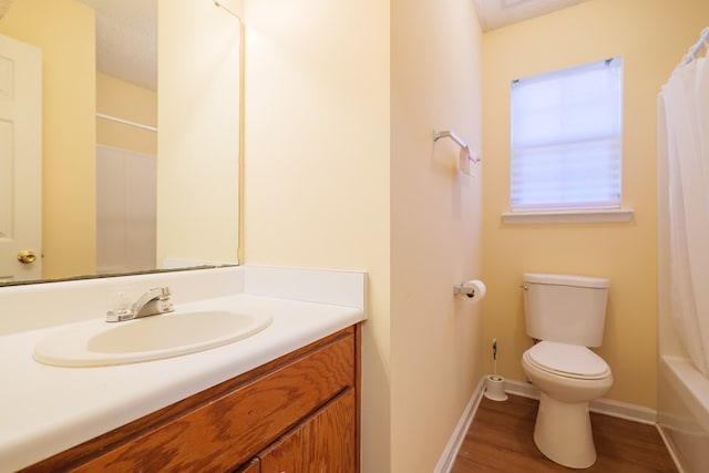 full bathroom with vanity, hardwood / wood-style flooring, toilet, a textured ceiling, and shower / tub combo