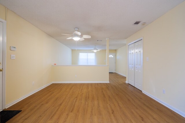 spare room with ceiling fan, a textured ceiling, and light hardwood / wood-style flooring