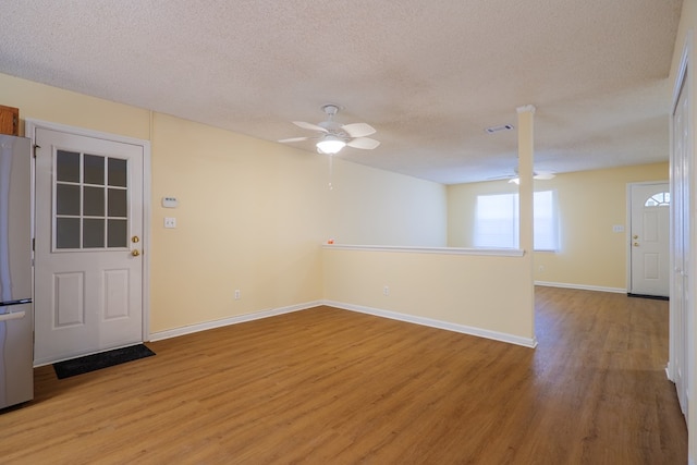 spare room featuring a textured ceiling, light hardwood / wood-style flooring, and ceiling fan