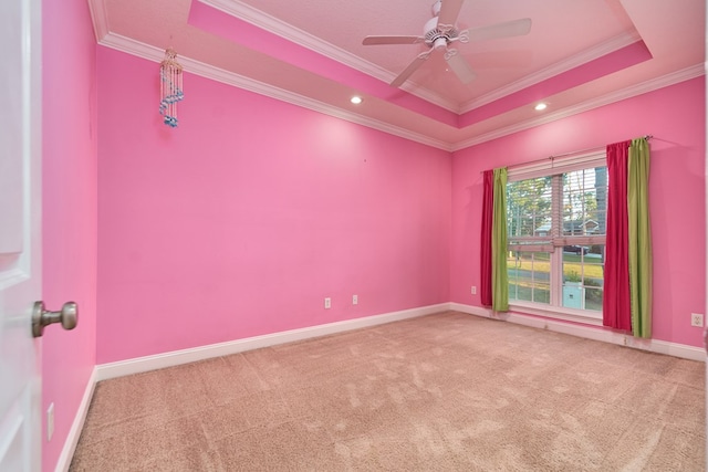 carpeted empty room featuring a tray ceiling, ceiling fan, and crown molding